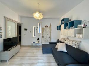 un soggiorno con divano blu e TV di Villa Antonietta 1, giardino privato, mare e pineta a Bibione