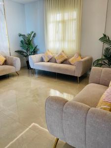 Husin Al Khaleej Hotel Apartment في سيب: غرفة معيشة مع كنبتين وأريكة