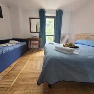 sypialnia z 2 łóżkami, stołem i oknem w obiekcie Chalet Monte Nebius w mieście Vinadio