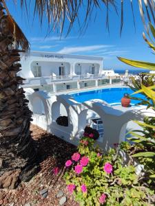 a villa with a swimming pool and flowers at Agapi Villas in Karterados