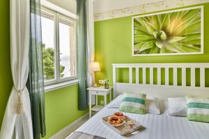 a bedroom with green walls and a bed with a tray of food on it at Holiday Home Labineca in Gradac