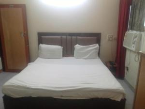 a bed with white sheets and pillows in a room at Hotel Diamond palace 45C in Chandīgarh