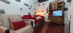 a living room with a couch and a tv at La Casona Del Almendro in San Bartolomé