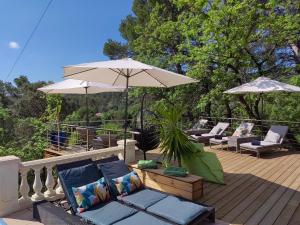 una terraza con sillas y sombrillas en una casa en Villa Bayarde, en Figanières