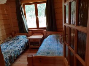a bedroom with two beds in a log cabin at Dom nad Jeziorem Wigry Suwalszczyzna in Gawrych Ruda