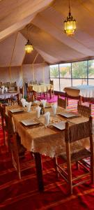 a dining room with a table and chairs in a tent at Krich Camp in Merzouga