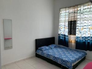 1 dormitorio con 1 cama con cortina y ventana en Homestay Sumayyah, en Kuantan