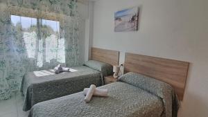 two beds in a room with two masseuses at EUROPA I - Playa de Miramar in Miramar +133 photos
