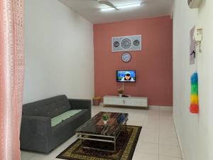 a living room with a couch and a tv at Homestay Sumayyah in Kuantan