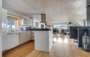 a large kitchen with white cabinets and a counter at Beautiful Home In Hvide Sande With 4 Bedrooms, Wifi And Private Swimming Pool in Bjerregård