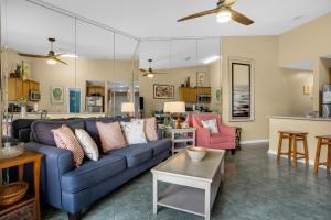 uma sala de estar com um sofá azul e uma cozinha em Gulfview II 327 em Destin