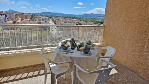 a table on a balcony with a view of a city at EUROPA I - Playa de Miramar in Miramar