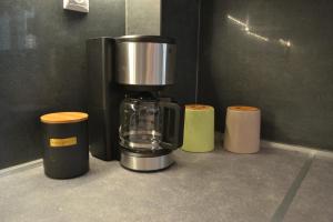Kalamaria brand new 1 bedroom apartment في سلانيك: وجود آلة صنع القهوة على رأس طاولة