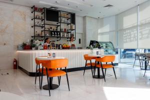 a restaurant with two people standing at a counter at Viola Hotel Apartments in Sharjah