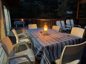 een tafel met een kaars op een terras met stoelen bij Forest Drive Holiday Home in Natureʼs Valley
