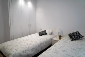 two beds sitting next to each other in a bedroom at Preciosos apartamentos Riojaland en Lardero in Lardero
