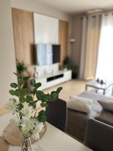 una sala de estar con un jarrón con flores sobre una mesa en Apartamento Al-Alba Golf Resort Valle del Este, en Vera