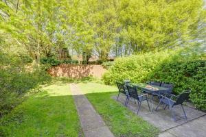 a patio with a table and chairs in a yard at Park View - sleeps 7 great for 5 contractors in Warrington