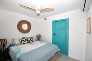 1 dormitorio con puerta azul y ventilador de techo en Casa Markoli, en Jávea