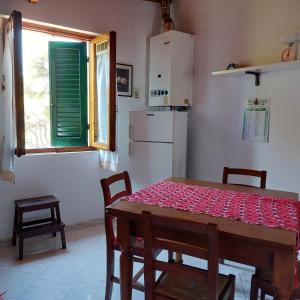 cocina con mesa, sillas y nevera en Appartamento a due passi dal mare a Quercianella, en Quercianella