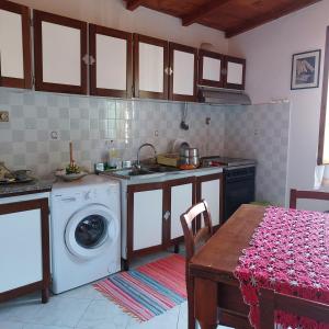 cocina con lavadora y mesa en Appartamento a due passi dal mare a Quercianella, en Quercianella