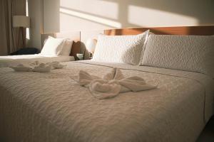 a bed with two white towels on it at Sol Vicitoria Marina in Salvador