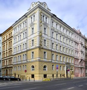 un edificio giallo sul lato di una strada di Amigo City Centre a Praga