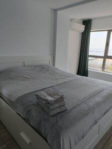 a white bedroom with a bed with a window at Olimp sea view in Olimp