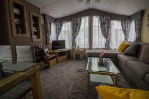 a living room with a couch and a tv at 8 Berth Caravan For Hire Near Clacton-on-sea In Essex Ref 26287e in Clacton-on-Sea