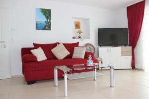 ein Wohnzimmer mit einem roten Sofa und einem Tisch in der Unterkunft Bodensee Pension in Überlingen