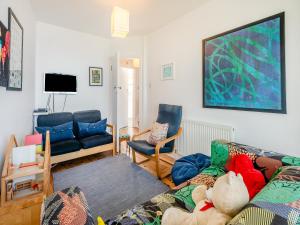 ein Wohnzimmer mit einem Sofa, Stühlen und einem TV in der Unterkunft Sea Wrack in Sheringham
