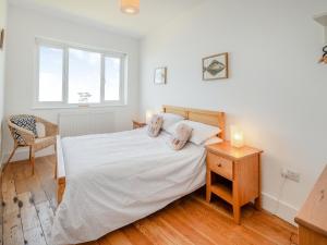 ein Schlafzimmer mit einem Bett, einem Tisch und einem Stuhl in der Unterkunft Sea Wrack in Sheringham