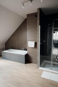a bathroom with a bath tub and a shower at Pod Wielkim Wozem in Jerutki