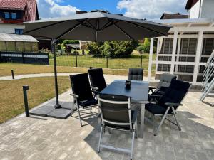 a table and chairs under an umbrella on a patio at Haus-Holiday Walkenried - Harz in Walkenried