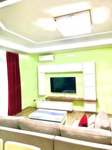 a living room with a couch and a flat screen tv at Premium Apartment Shengjin in Shëngjin