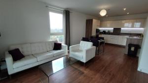 a living room with a couch and chairs and a kitchen at Riverview Amazing 2Bed 2Bath Apt wParking Sleeps 6 Comfortably in London