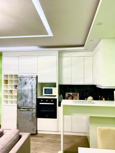 a kitchen with white cabinets and a stainless steel refrigerator at Premium Apartment Shengjin in Shëngjin
