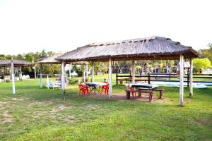 una zona de picnic con mesas y una cabaña con piscina en Cabañas Los Búhos en Tristán Suárez