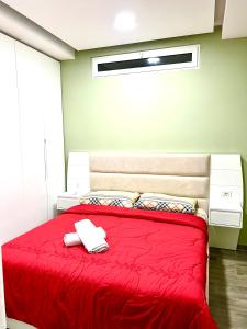 a bedroom with a red bed with a red blanket at Premium Apartment Shengjin in Shëngjin