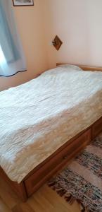 1 cama con marco de madera en una habitación en Zsike lak, en Igal