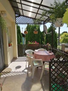 un patio con mesa y sillas bajo una pérgola en Zsike lak, en Igal