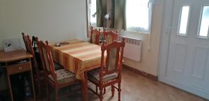 uma sala de jantar com uma mesa e cadeiras e uma janela em Zsike lak em Igal