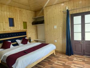 a bedroom with a large bed in a room with wooden walls at Irish Town Mussoorie in Mussoorie