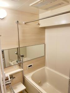 W łazience znajduje się wanna i umywalka. w obiekcie 大阪谷町橋の宿 w Osace
