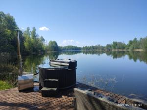 a trash can sitting on a dock next to a lake at Pelakys Glamping Lounge in Šlepečiai