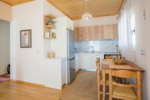 a kitchen with a wooden table and a kitchen with white cabinets at Oikia Demetria Lefkas in Nydri