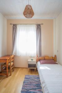 a bedroom with a bed and a window with a table at Oikia Demetria Lefkas in Nydri