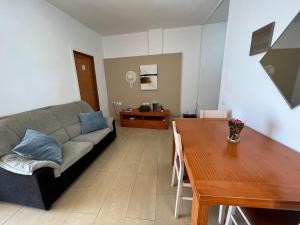 - un salon avec un canapé et une table dans l'établissement ALCAMAR Habitaciones con baño compartido en apartamentos rurales cerca al Mar!, à Alcalá