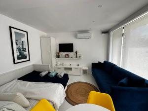 un soggiorno con un divano blu e una TV di Oxygen studio a Jupiter