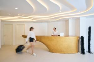 two women are standing at a desk in a lobby at Arte & Mare Elia Luxury Suites and Villas in Elia Beach +37 photos